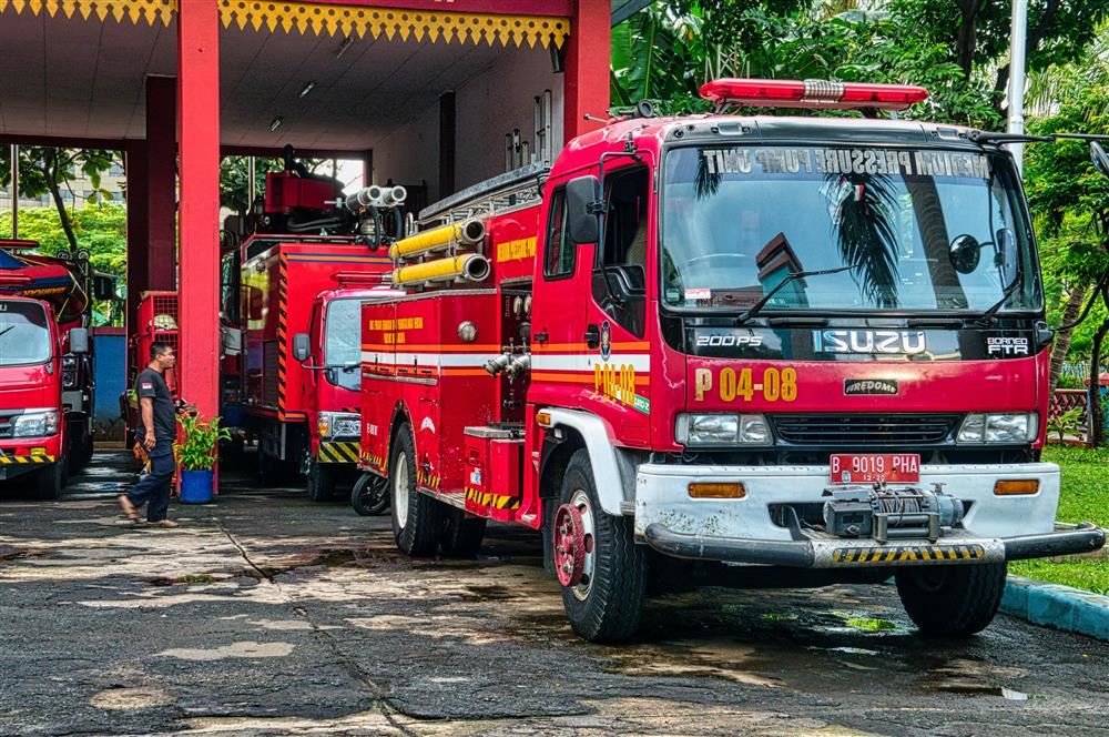 red fire truck coming out of a fire station 